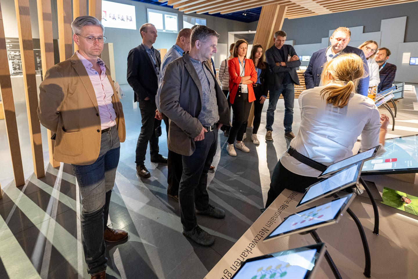 Stehende Personen schauen auf Bildschirme