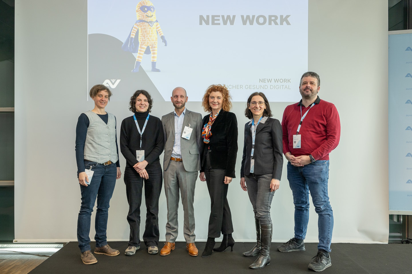 Gruppenbild mit Männern und Frauen auf der Bühne