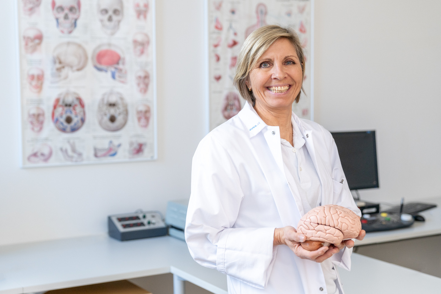 Psychologin im Behandlungszimmer hält ein Modell des menschlichen Gehirns in ihren Händen