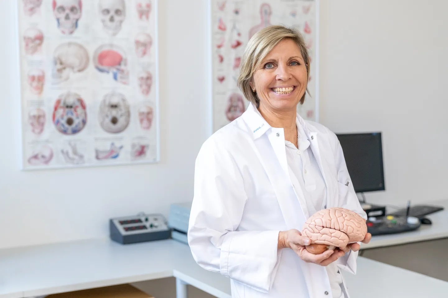 Psychologin im Behandlungszimmer hält ein Modell des menschlichen Gehirns in ihren Händen