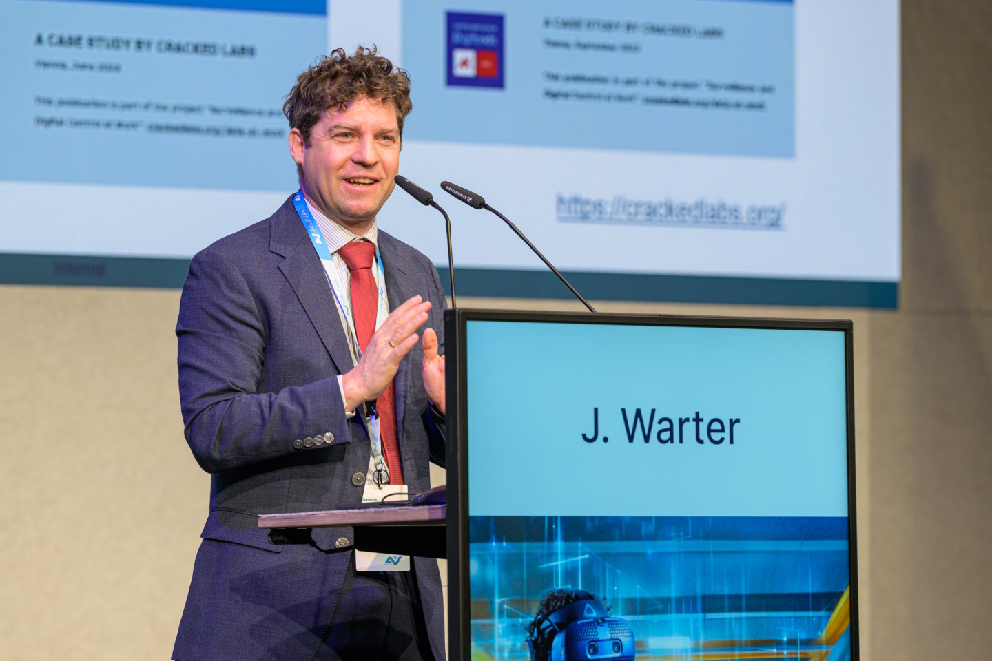 Ein Mann steht hinter einem Rednerpult auf der Bühne.