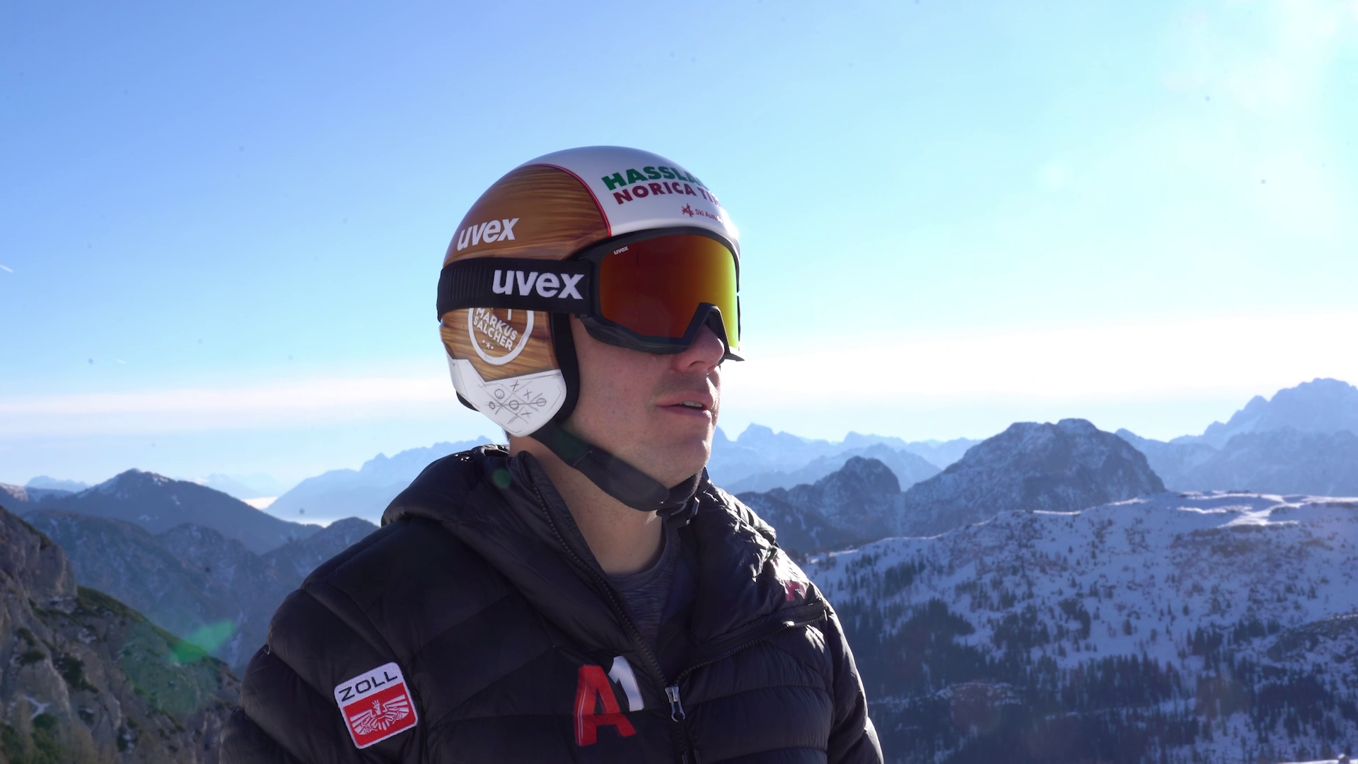 Vorschaubild aus dem Video: Markus Salcher steht vor der Bergkulisse mit Skihelm in der Sonne