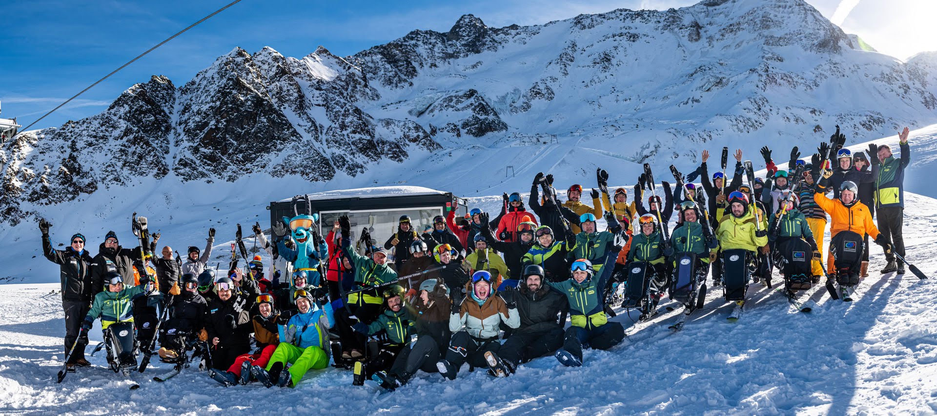 Gruppenbild aller Teilnehmenden und Helfer:innen beim Monoskikurs am Berg