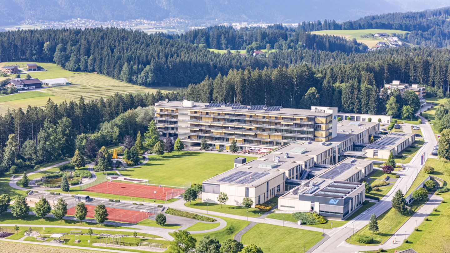 Luftaufnahme, die das gesamte Rehabilitationszentrum Häring und die umliegenden Wälder zeigt