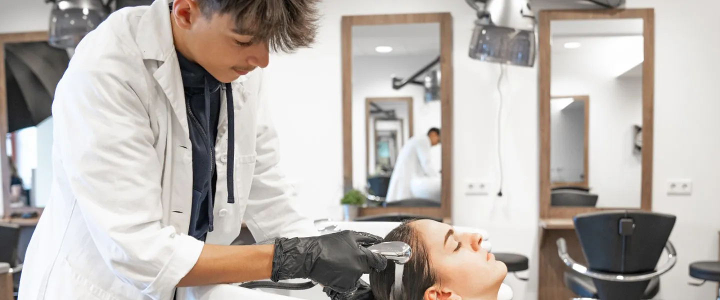 Friseure Starterpaket 1440 Credit MSK Friseurlehrling wäscht jungem Mädchen die Haare.