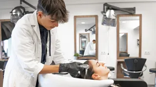 Friseure Starterpaket 1440 Credit MSK Friseurlehrling wäscht jungem Mädchen die Haare.