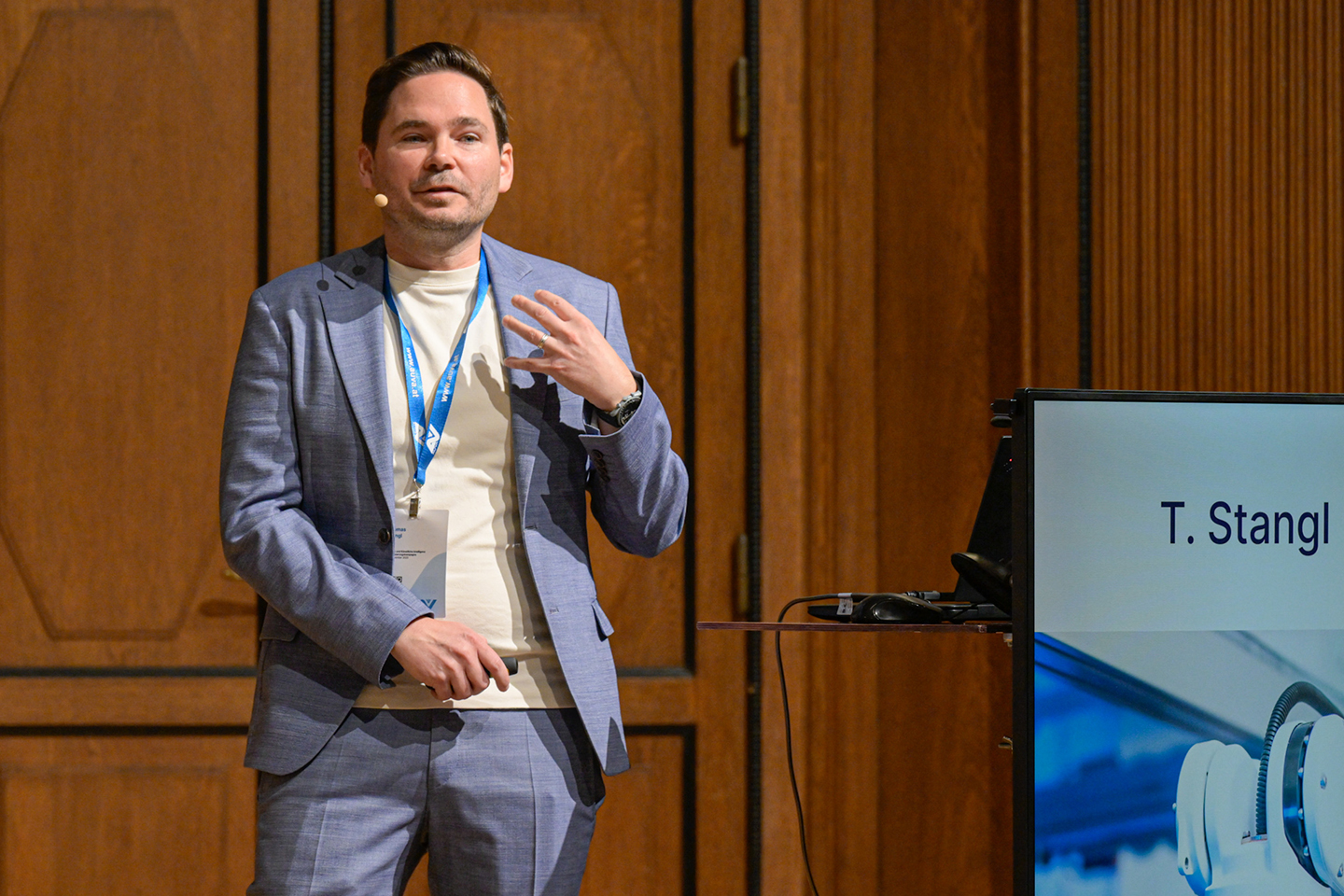 Ein Mann steht neben einem Rednerpult und spricht