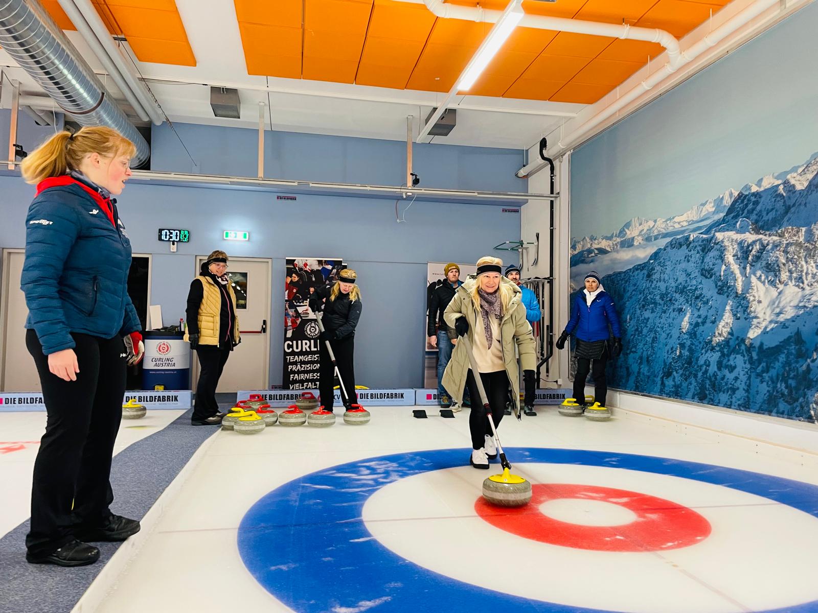 Eine Teilnehmerin in Aktion am Eis, seitlich und im Hintergrund von ihr sind fünf weitere Personen erkennbar. 