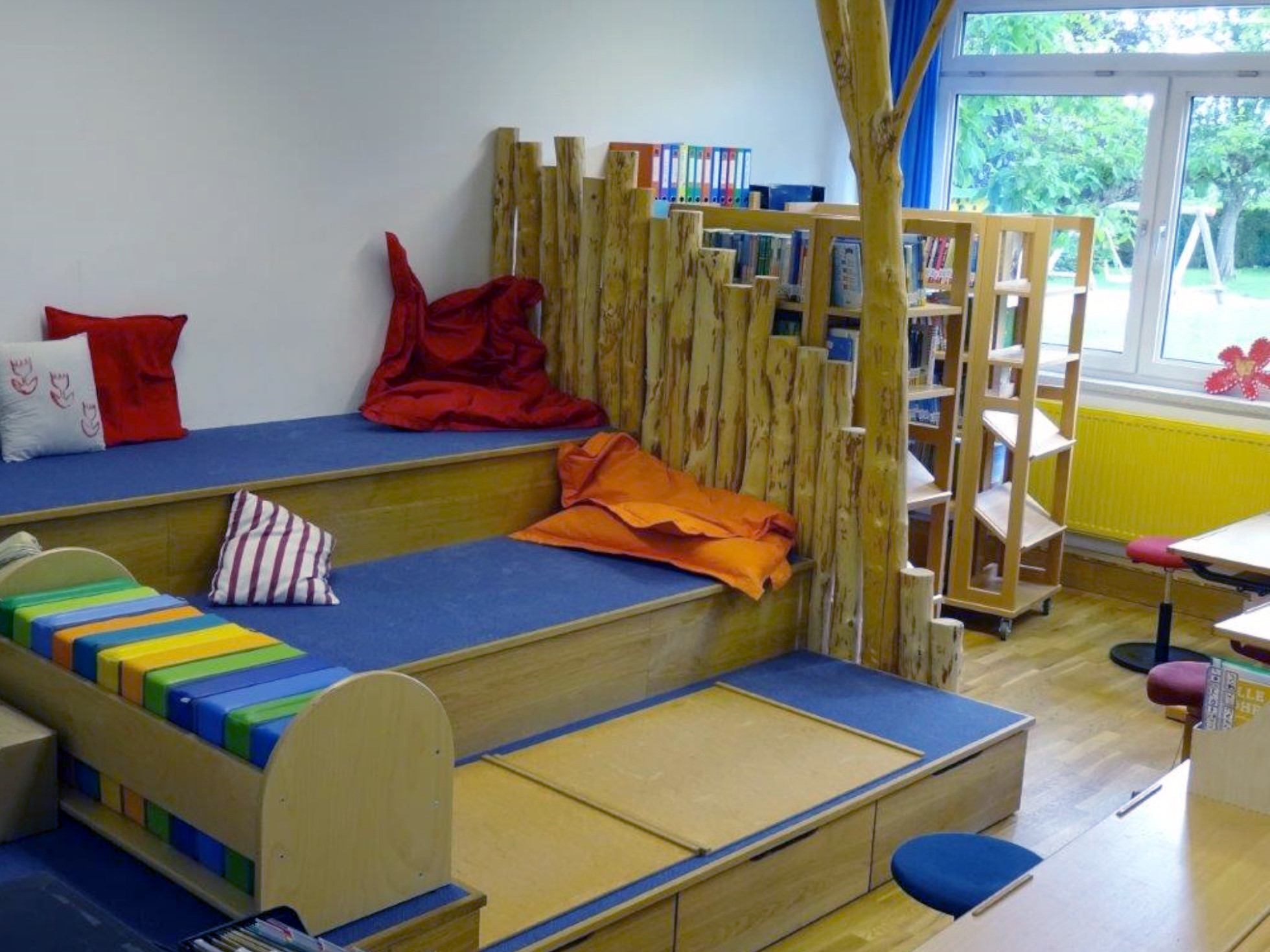 Lesetribüne mit Teppichen und Pölstern in einer Schulklasse