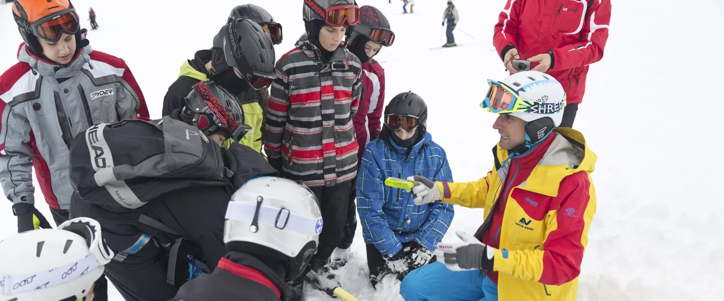 Eine Gruppe Schüler:innen mit AUVA-Safety-Guide im Schnee