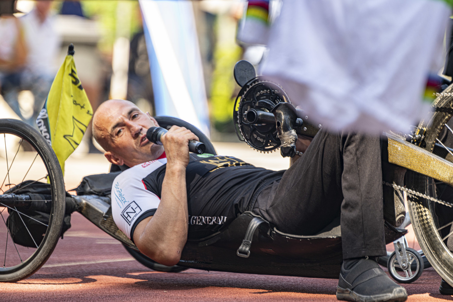 Moderator des Sportfestes liegt auf einem Handbike und spricht ins Mikrofon