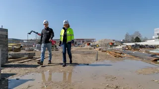 Bau Interview Doppler Edit 1440 1 Credit Kierner Eine Frau und ein Mann gehen auf einer Baustelle