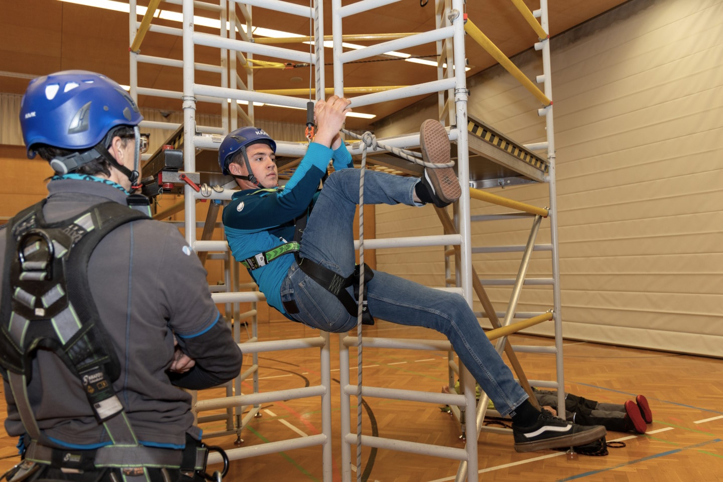Zwei junge Männer beim Abseilen am Klettergerüst