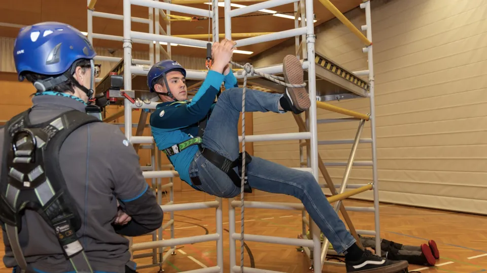 Zwei junge Männer beim Abseilen am Klettergerüst