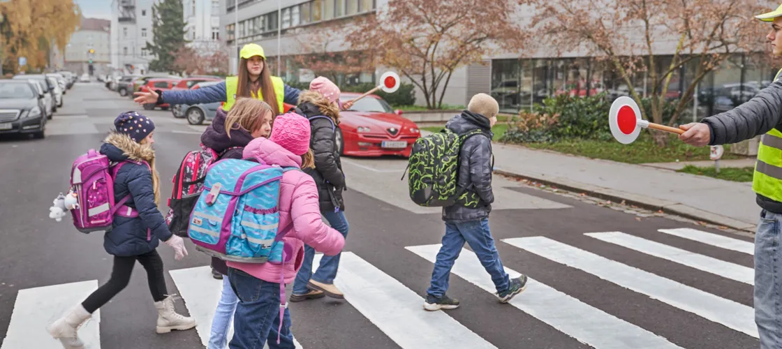KFV DSC0083 1440(C) KFV Bildstadt Kinder beim Überqueren eines Zebrastreifens, der von Schülerlotsen gesichert wird.