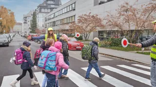 KFV DSC0083 1440(C) KFV Bildstadt Kinder beim Überqueren eines Zebrastreifens, der von Schülerlotsen gesichert wird.