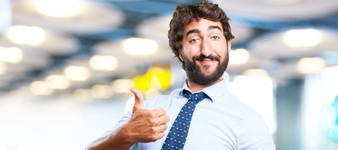01 Crazy Hero (C) Kues1 Freepik.Com Ironisch grinsender Mann in Business-Kleidung deutet "Daumen hoch"