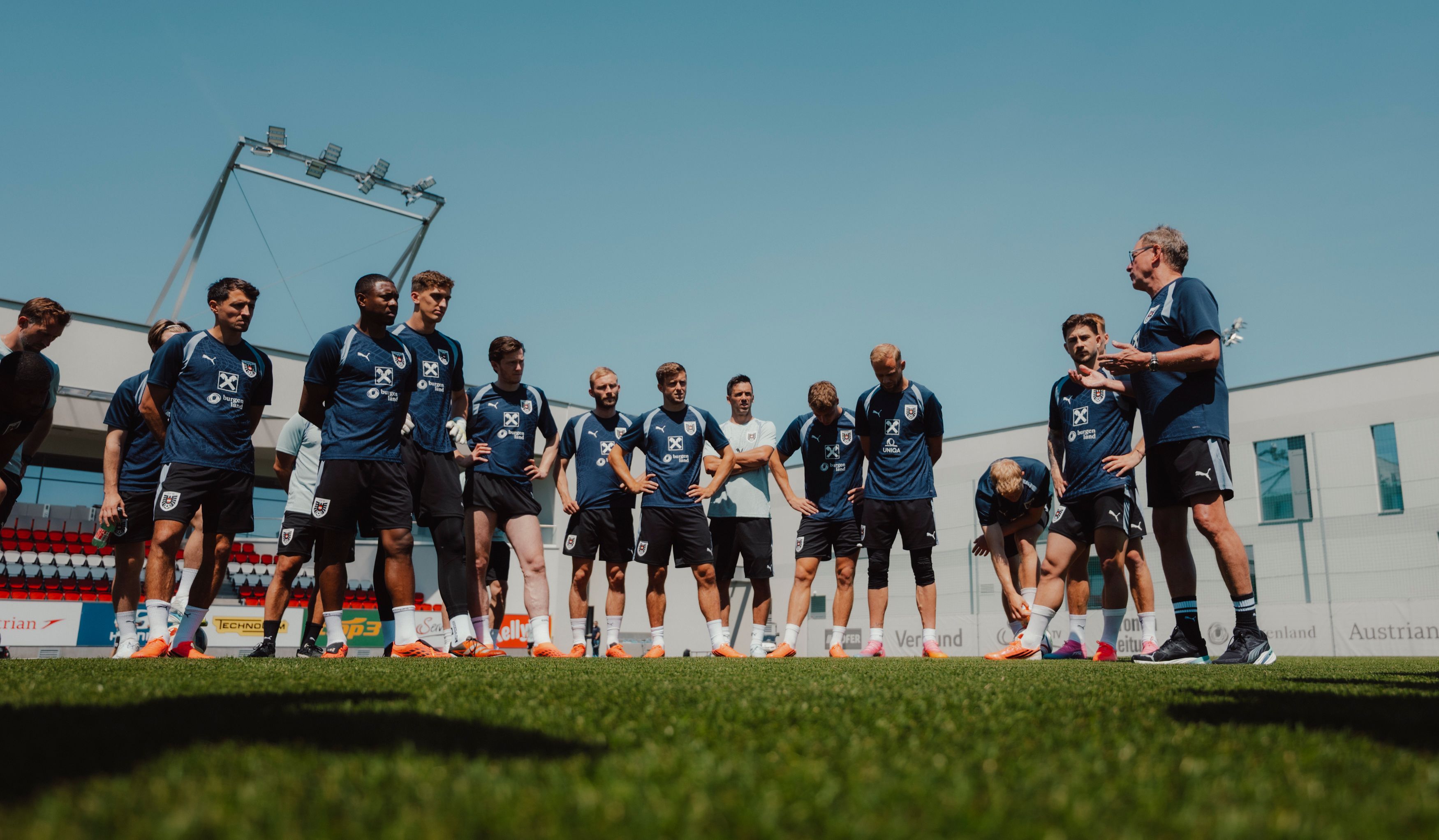 Der Trainer Ralf Rangnick spricht auf einem Trainingsplatz zu seinem Team, das einen Halbkreis gebildet hat