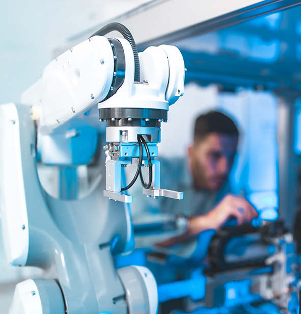 Im Vordergrund ein Roboter im Hintergrund das verschwommene Bild eines Mannes