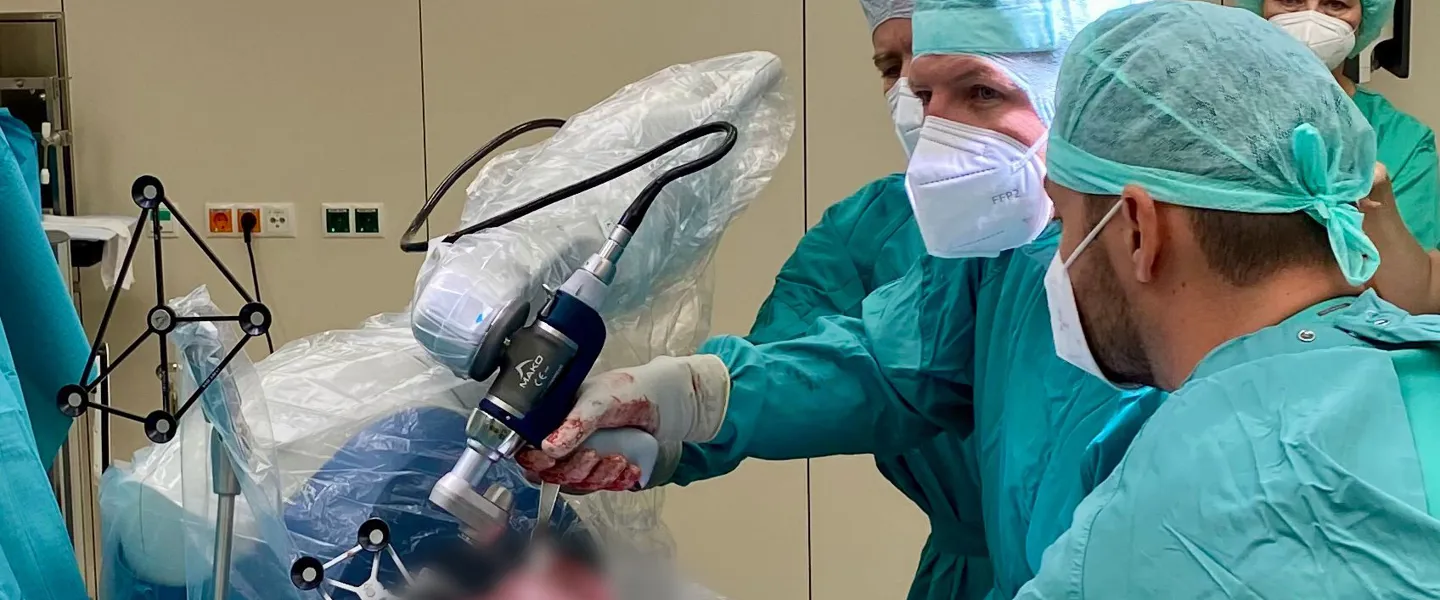 Ärzte während einer Operation, die unter Einsatz von Roboterchirurgie durchgeführt wird  Ärzte während einer Operation, die unter Einsatz von Roboterchirurgie durchgeführt wird
