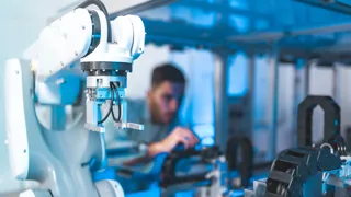 Industrieroboter im Einsatz Person arbeitet mit einem Industrieroboter.