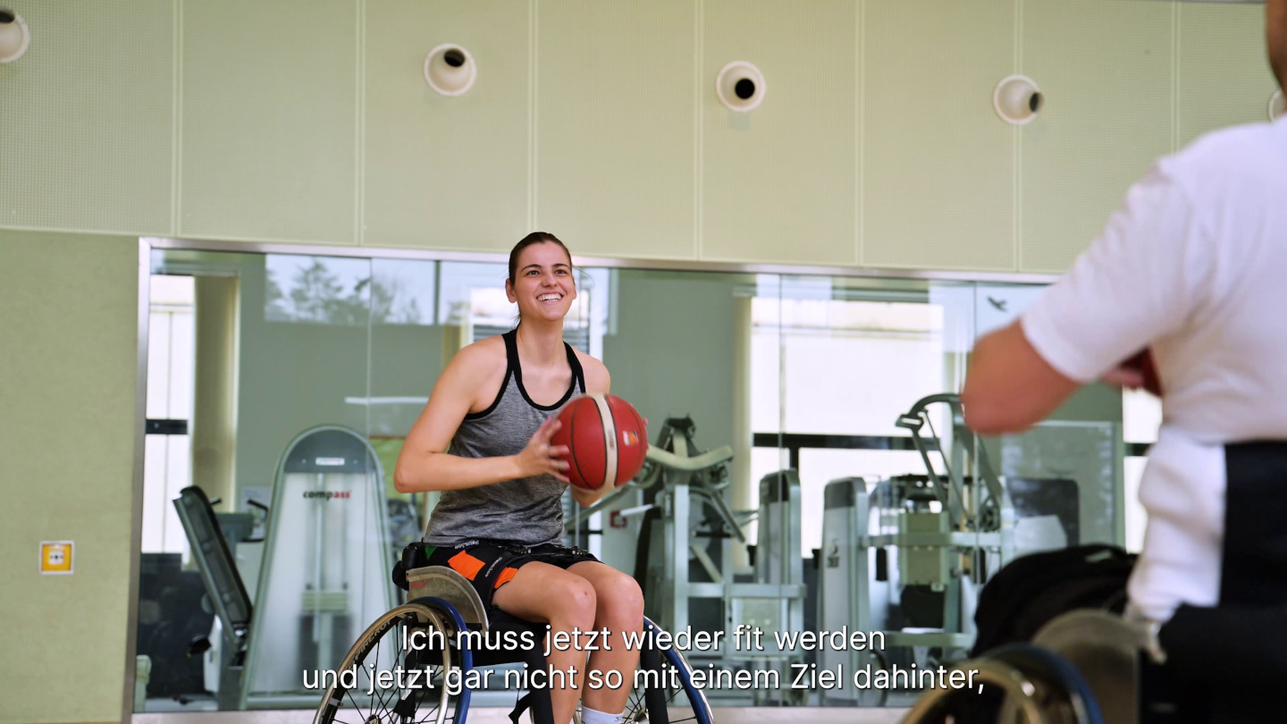 Rollstuhlbasketballerin Monika mitten im Spiel mit dem Basketball in der Hand