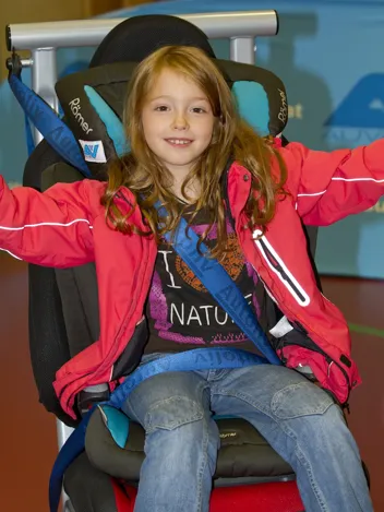 Mädchen sitzt angeschnallt in einem Kindersitz