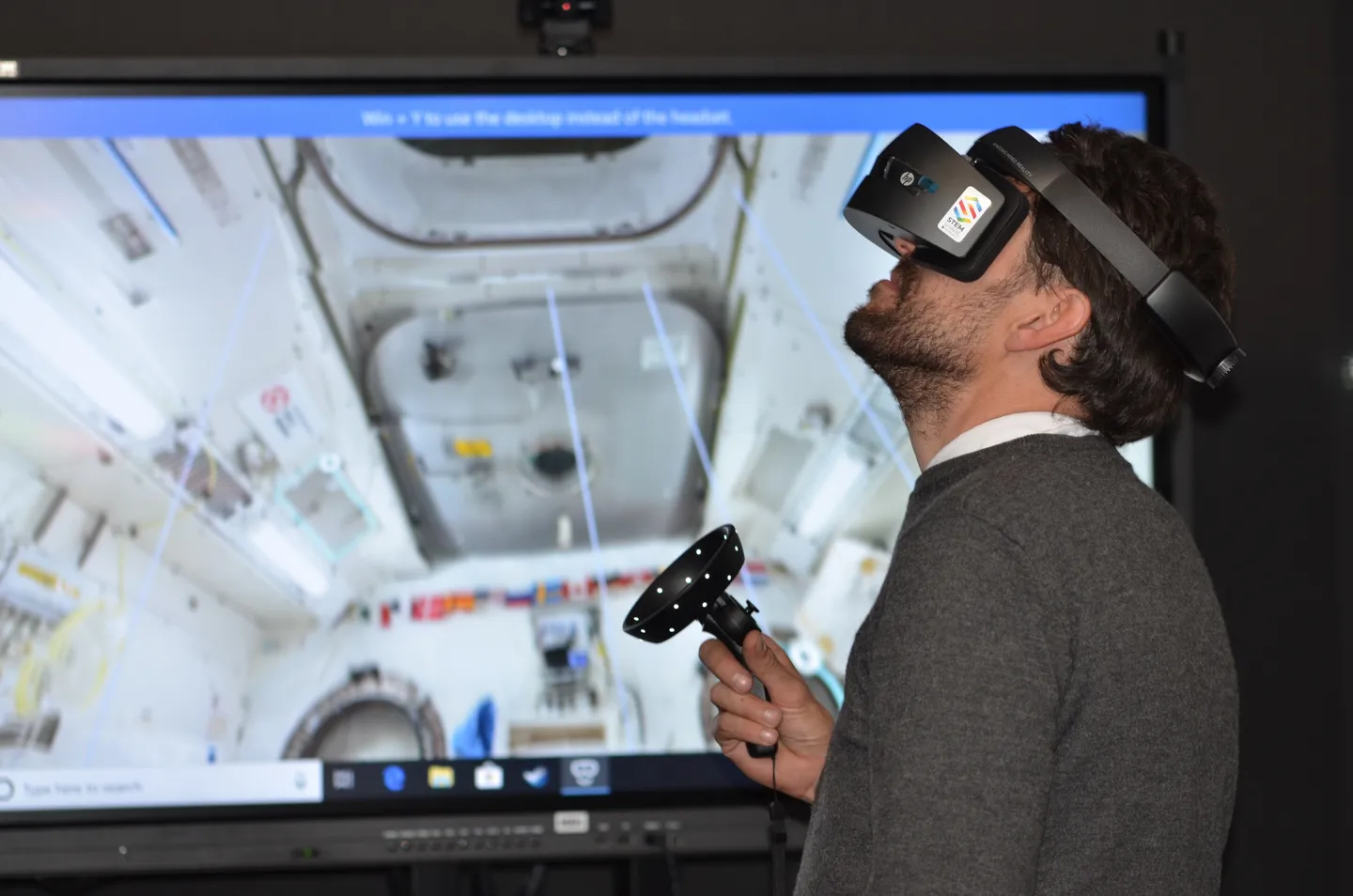 Ein Mann mit VR-Brille und Joystick in der Hand beim Ausführen einer Simulation