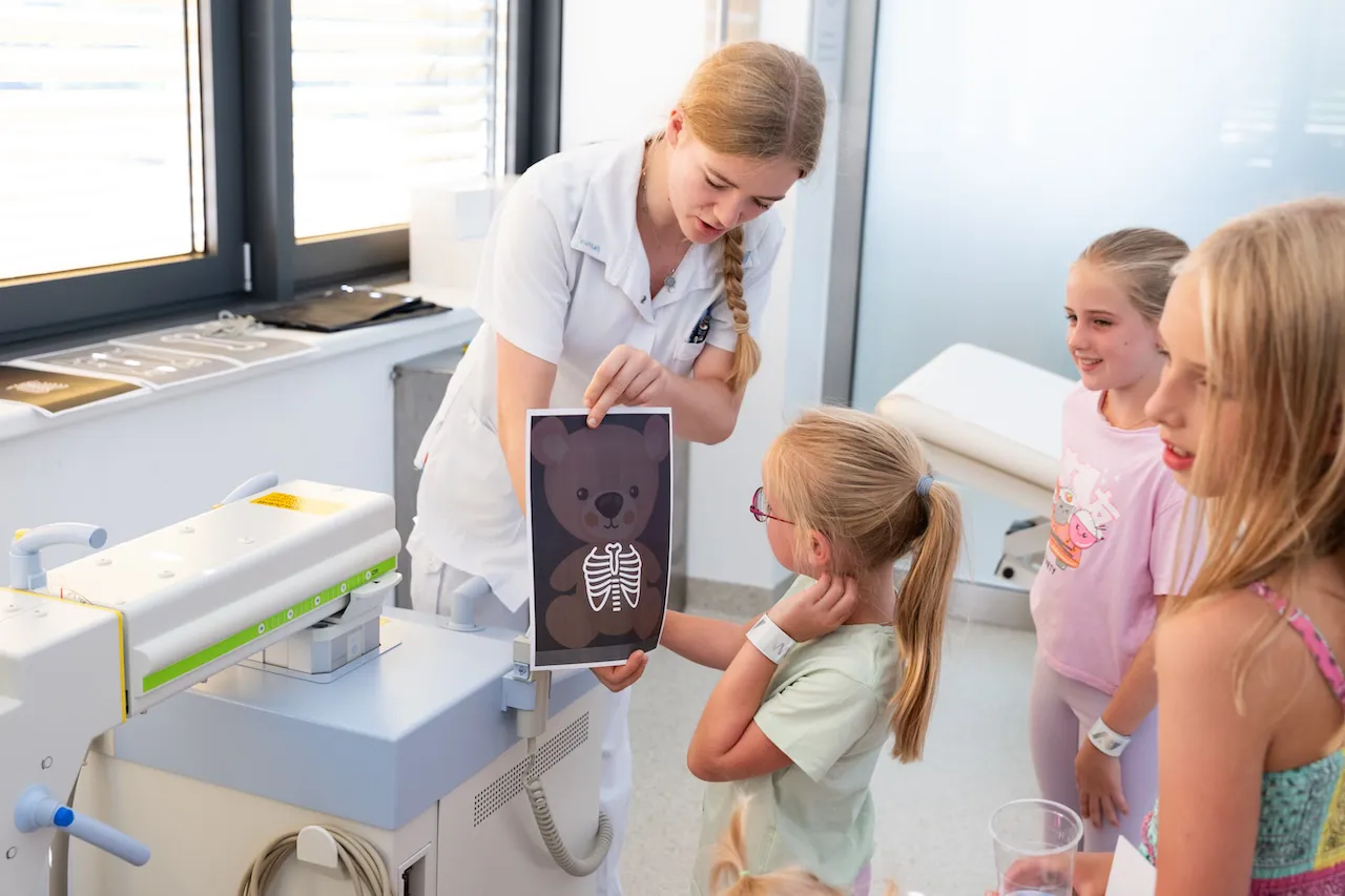 Eine Mitarbeiterin des Rehazentrums mit drei Kindern bei der im Rahmen der Feier veranstalteten Kuscheltierambulanz