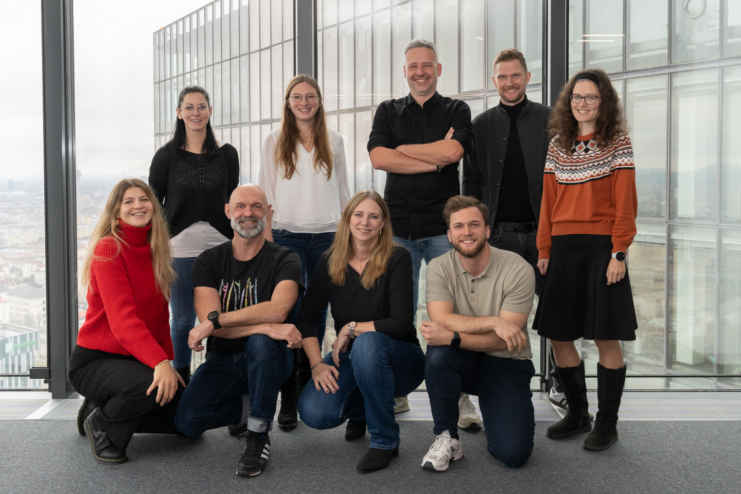 Gruppenbild von fünf stehenden und vier sitzenden Mitarbeitenden des Teams Kommunikation der AUVA