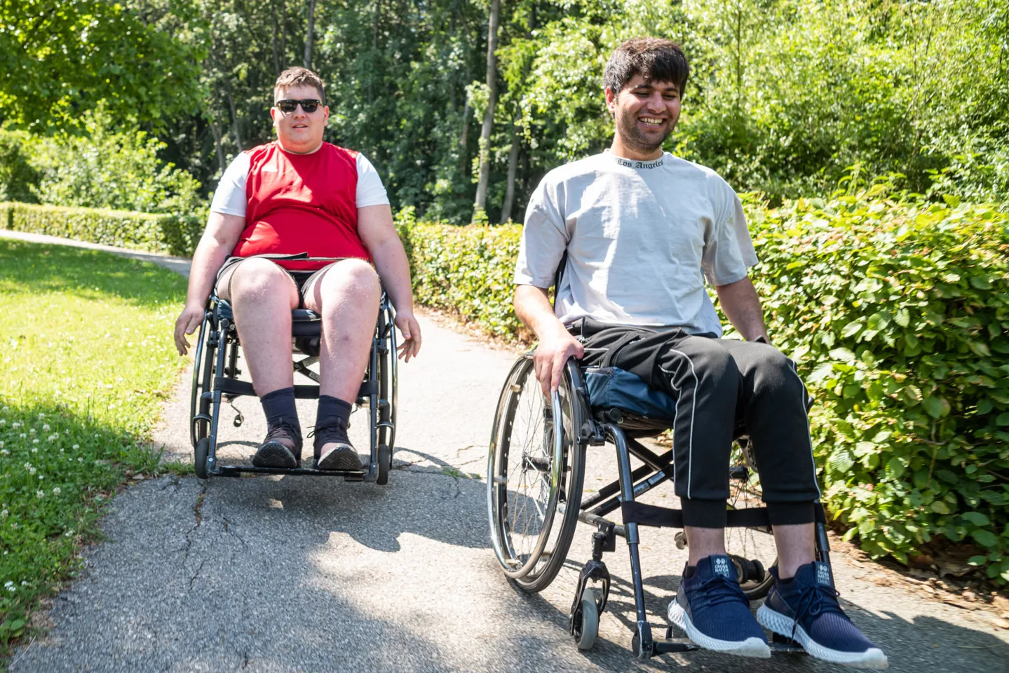 Zwei Patienten beim Rollstuhltraining in den Parkanlagen eines Rehazentrums Zwei Patienten beim Rollstuhltraining in den Parkanlagen eines Rehazentrums