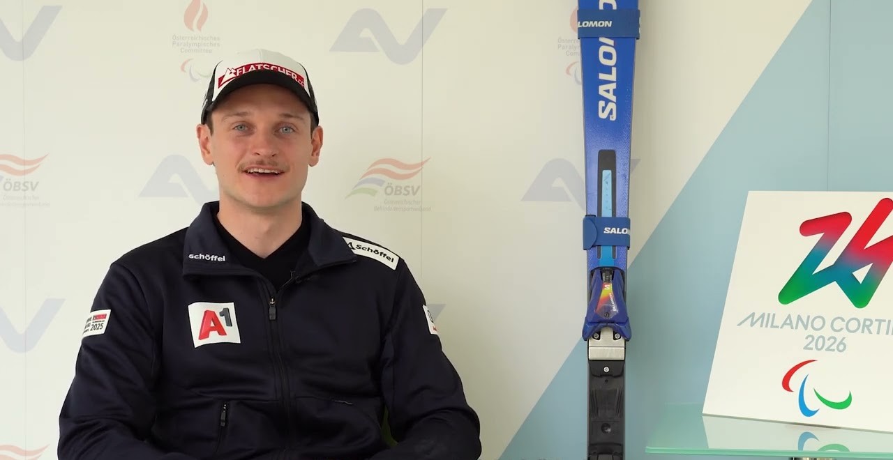 Thomas Volgger mit Ski, im Hintergrund eine Wand mit Logos von AUVA, ÖPC und ÖBSV