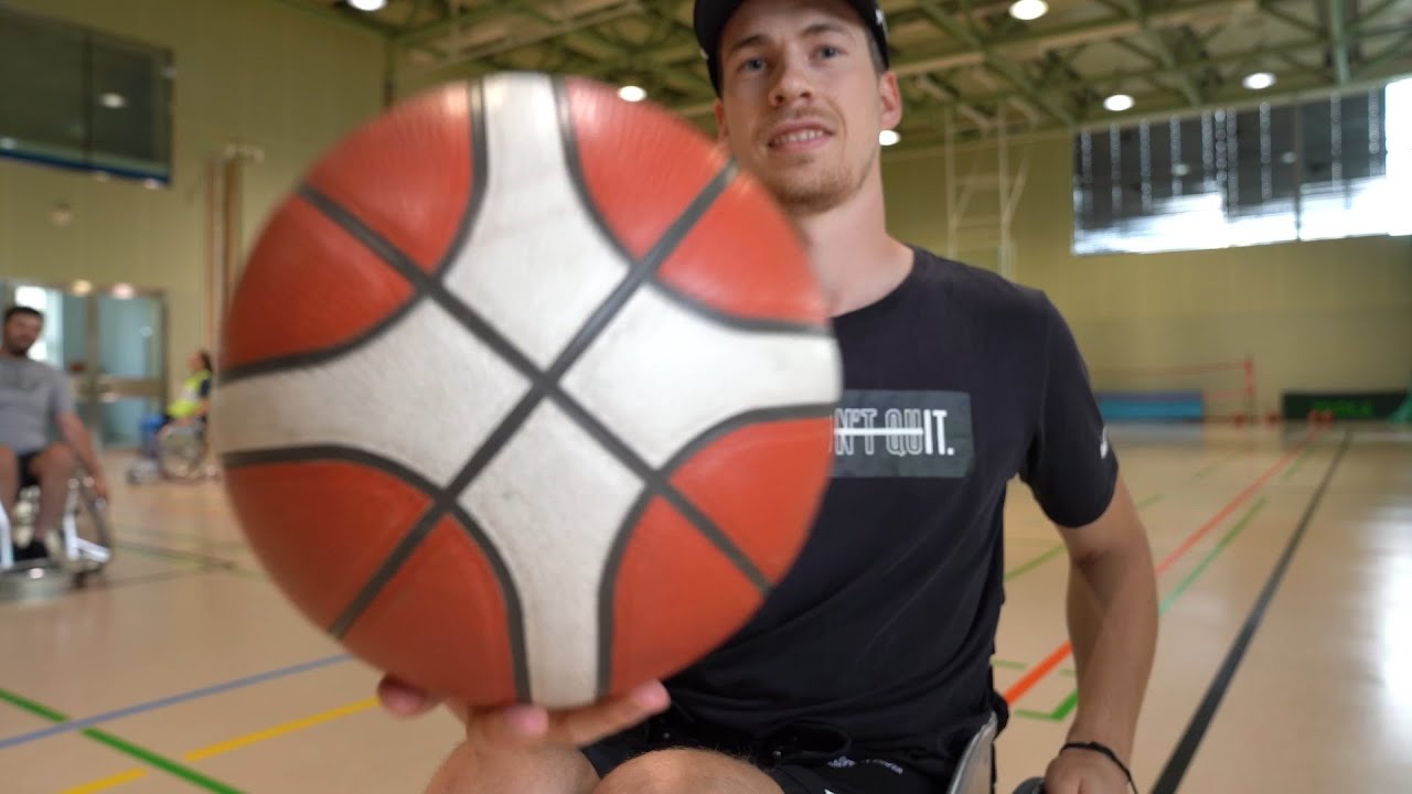 Vorschaubild aus dem Video: Junger Mann hält einen Basketball in die Kamera