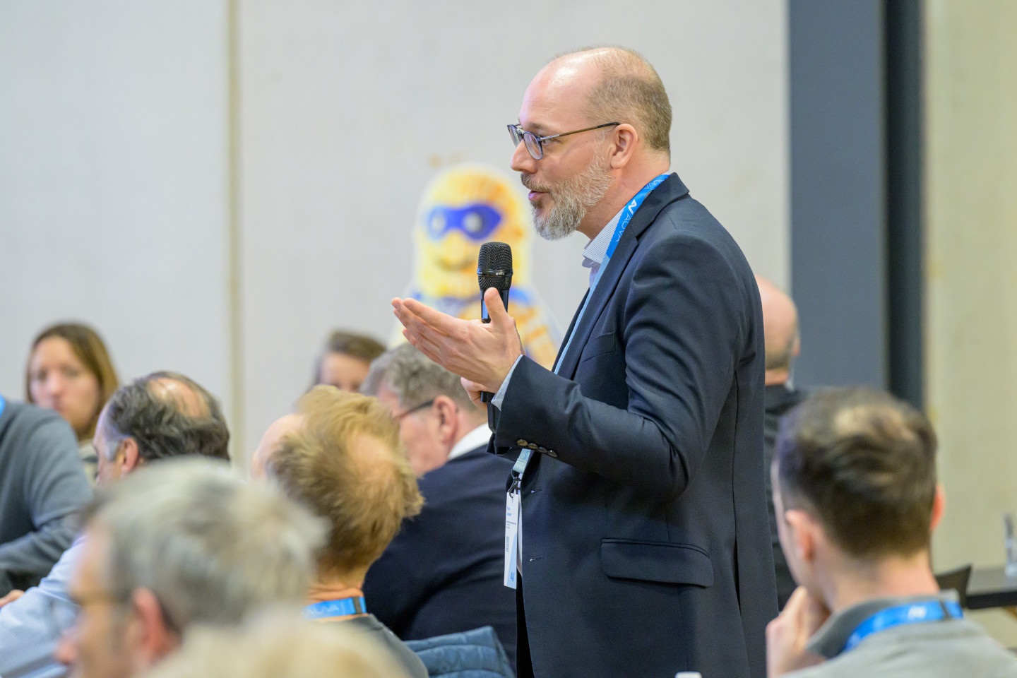 Ein Mann mit Mikrofon steht im Publikum 