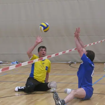 Zwei beinamputierte Männer spielen Sitzball.