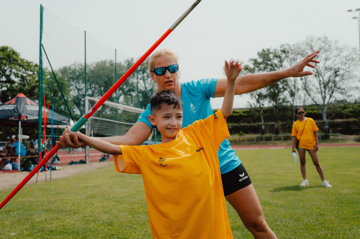 Paralympics-Athletin Natalija Eder unterstützt ein Kind beim Speerwurf