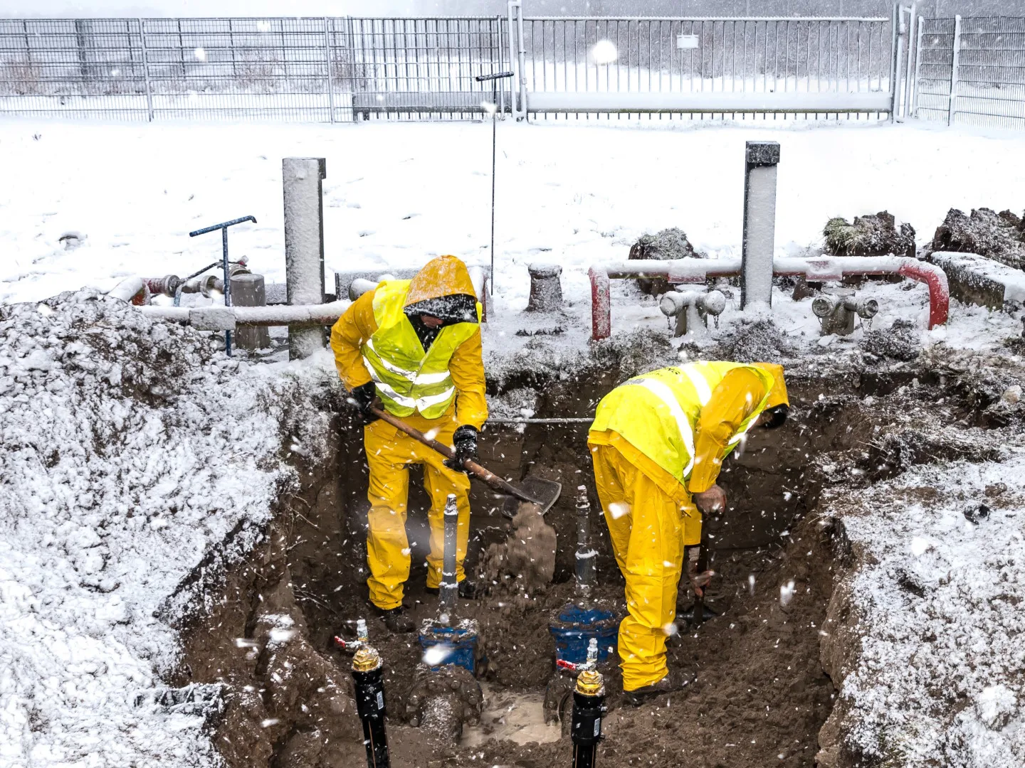 AdobeStock_184605080-1440-(c)mjowra_edit2 Zwei Bauarbeiter bei Arbeiten in winterlicher Baugrube