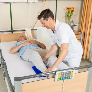 M105 Transfer Im Bett Nach Oben Rutschen Pflegefachkraft hilft Patient im Bett nach oben zu rutschen