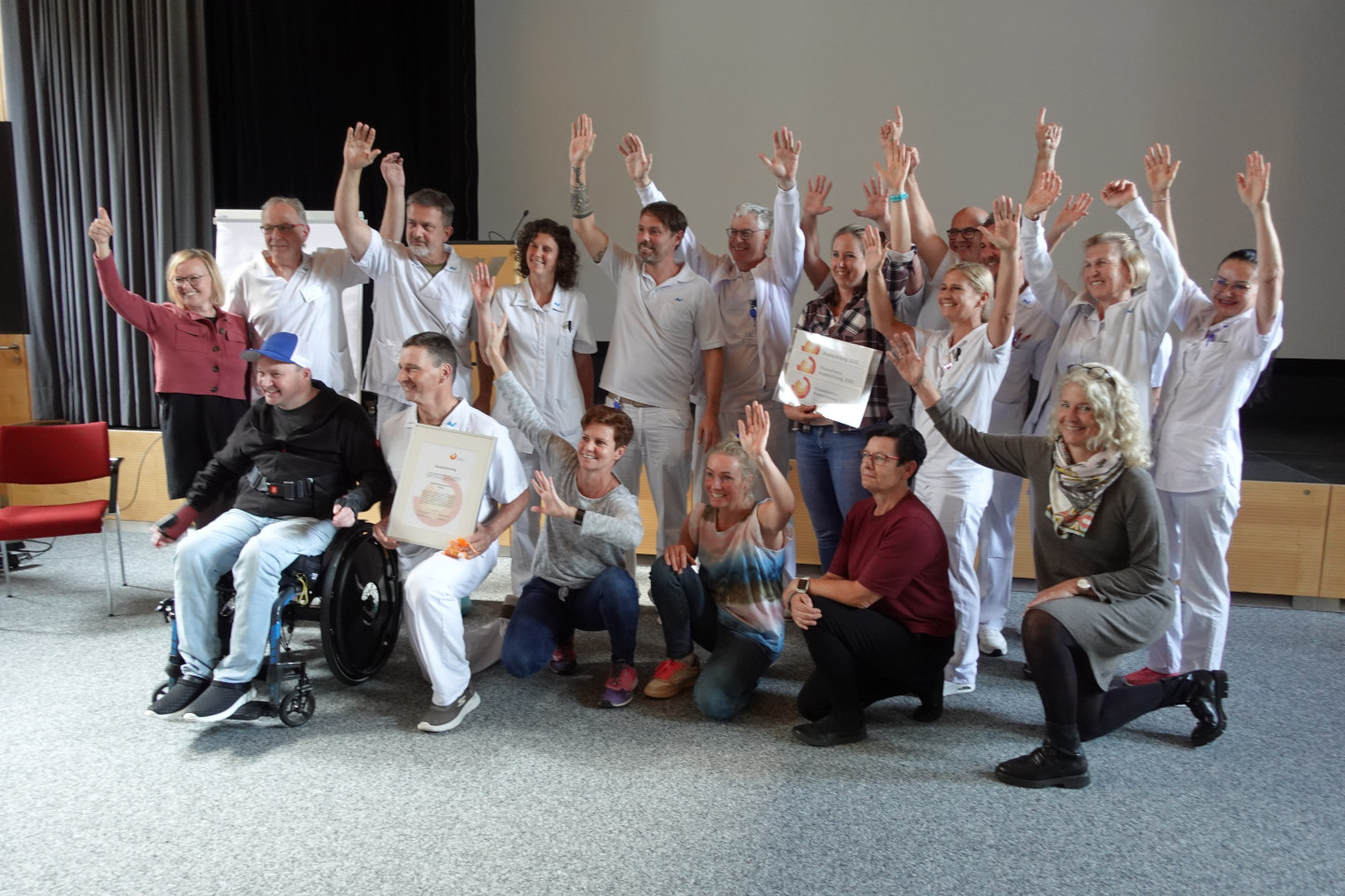 Gruppenfoto vom Team des AUVA-Rehabilitationszentrums Häring, das die Kinästhetik-Auszeichnungsurkunde präsentiert