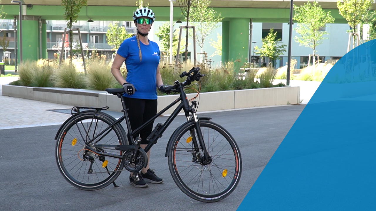 Frau steht neben Fahrrad