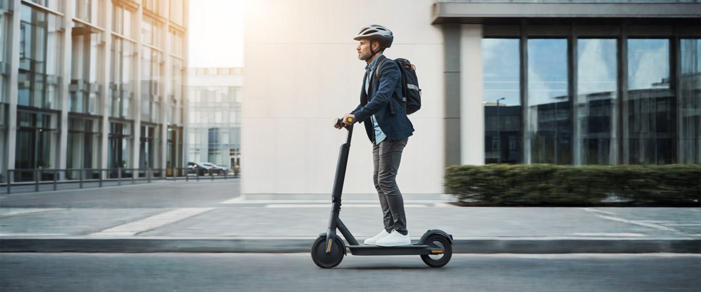 Ein Mann fährt auf einem E-Scooter in einer Stadt