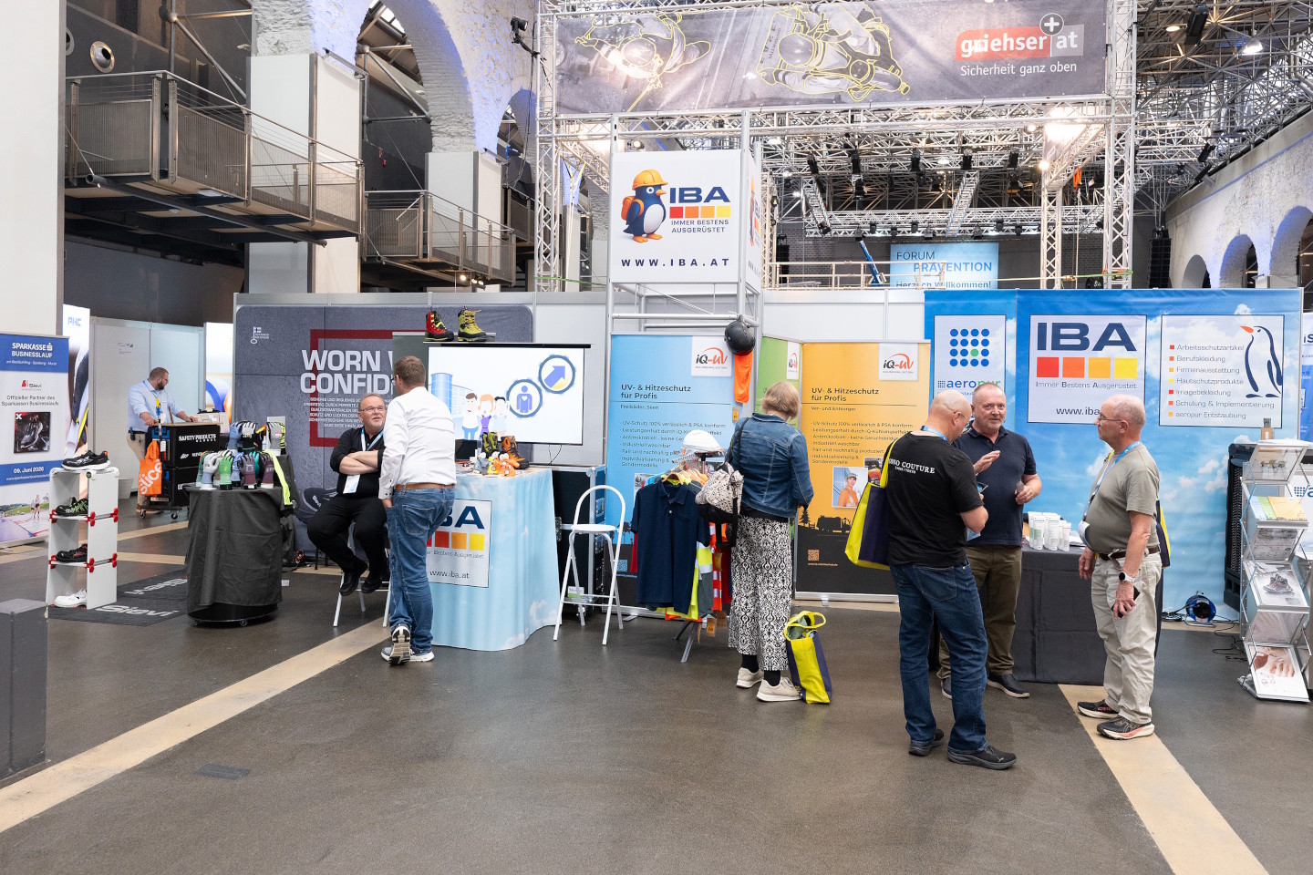 Menschen unterhalten sich vor den Messeständen der Ausstellung Prävention aktuell