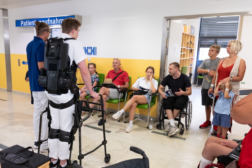 Mehrere interessierte Gäste mit zwei Mitarbeitern des Rehazentrums bei einer Führung im Bereich der Patientenaufnahme