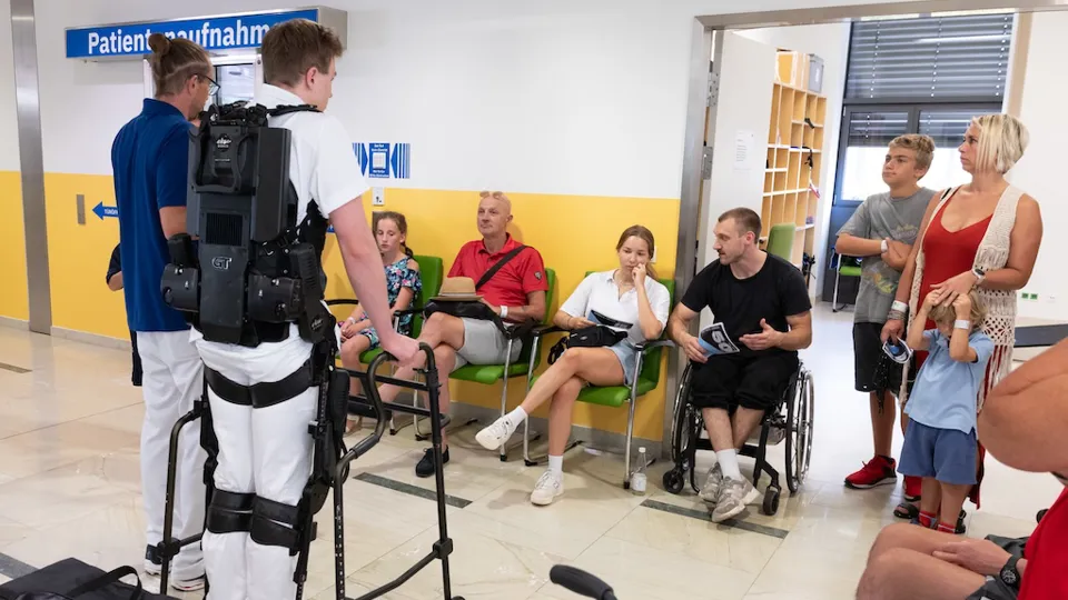 Mehrere interessierte Gäste mit zwei Mitarbeitern des Rehazentrums bei einer Führung im Bereich der Patientenaufnahme