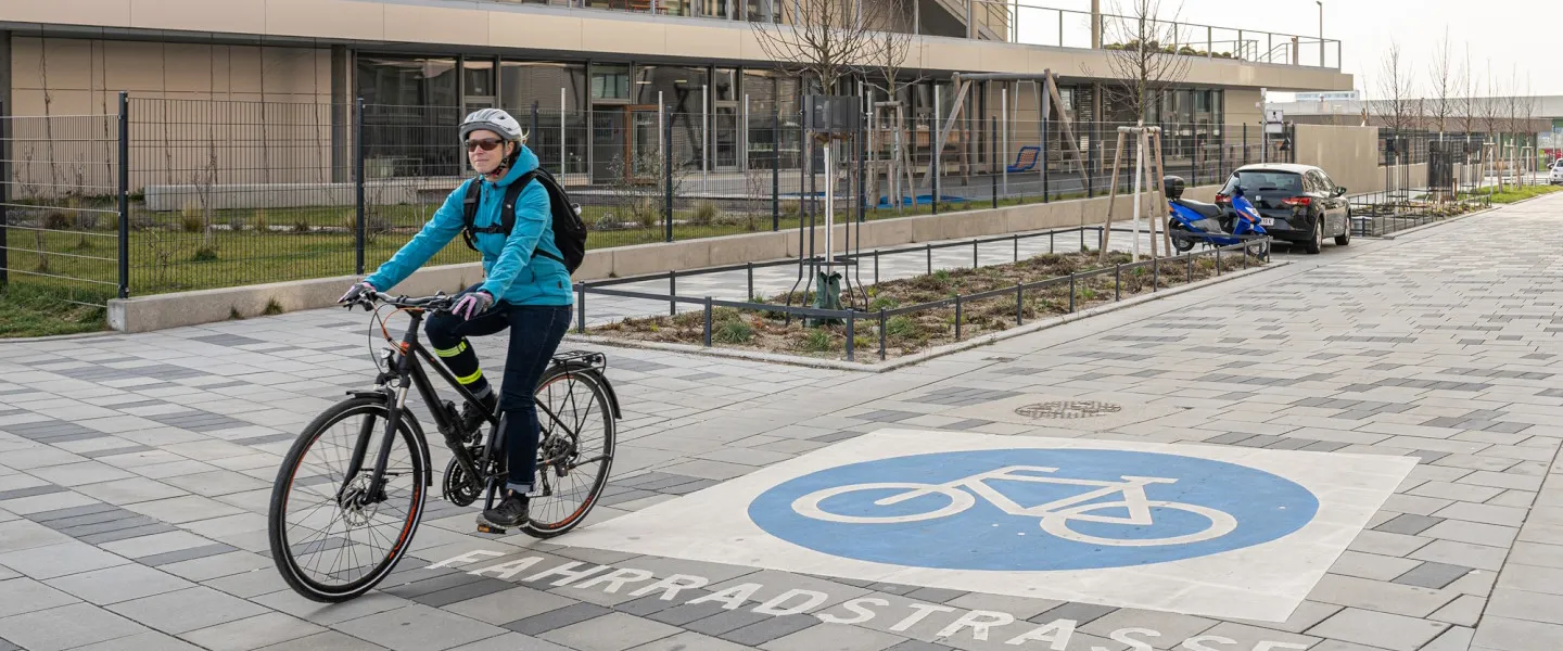 Fahrrad Infoseite 1440 Credit R.Reichhart Frau auf Fahrrad fährt in einer Fahrradstraße