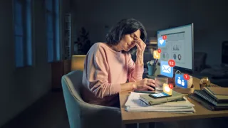 AUVA Technostress Sujet 1440 Credit Digitalwerk & Vienna Paint Studios Eine Frau sitzt vor einem Bildschirm und stützt den Kopf in die Hand. Vor dem Monitor erscheinen Icons für eingegangene E-Mails, Telefonate und Chat-Nachrichten.