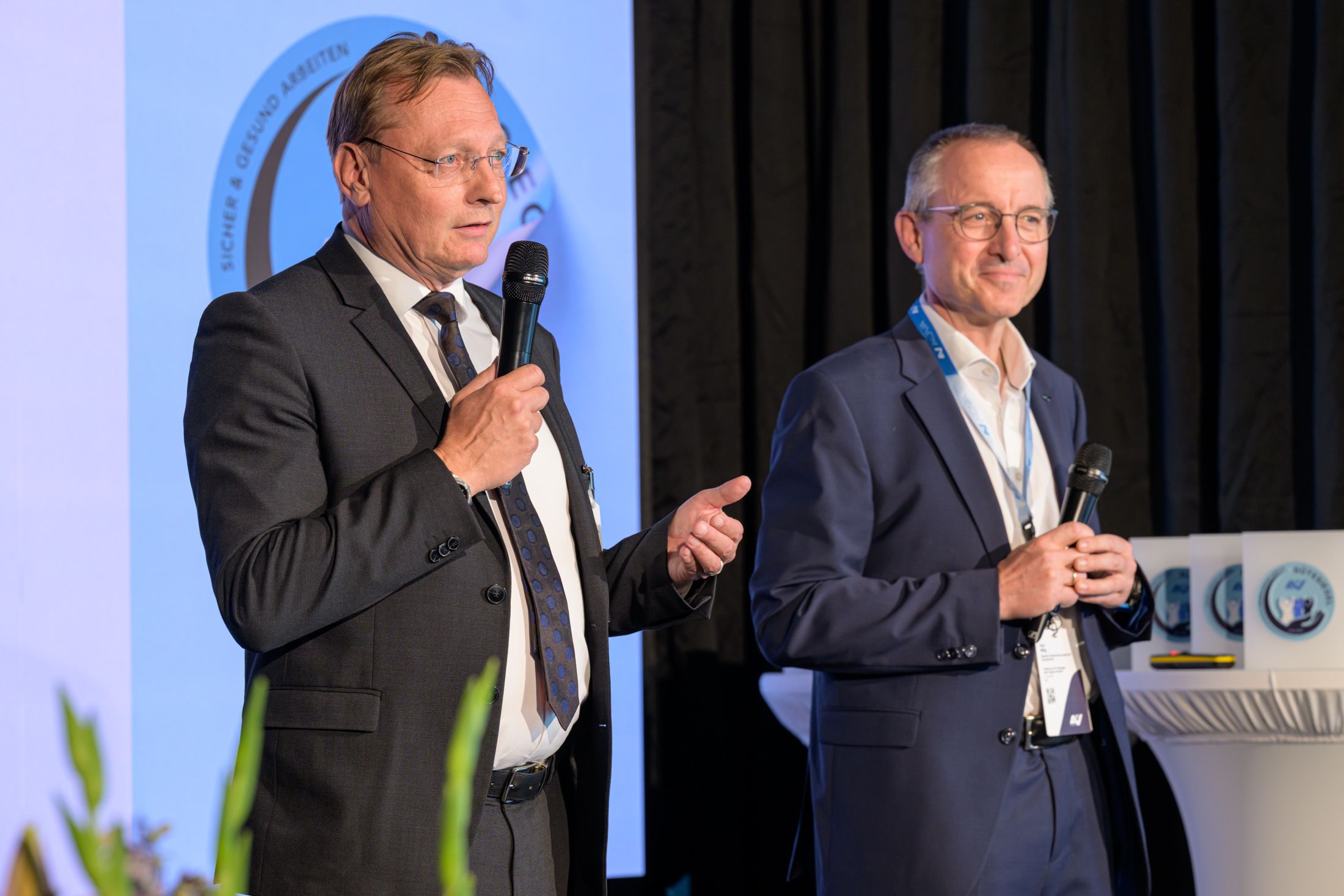 Roland Pichler (Stv. Generaldirektor AUVA) und Klaus Wittig (Leiter Sicherheitstechnische Prüfstelle der AUVA) sprechen auf der Veranstaltungsbühne