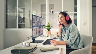 Frau im Mobile Office bei Online Besprechung Eine Person arbeitet im Mobile Office. Sie hört aktiv der Online-Besprechung zu.