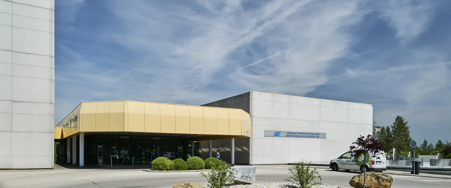 Vorderansicht des Rehabilitationszentrums Weißer Hof mit sichtbarem Eingang und Einfahrt.