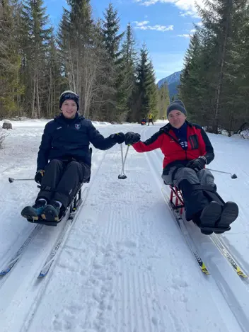 Zwei Teilnehmende des Trainings in Aktion mit Sitzschlitten